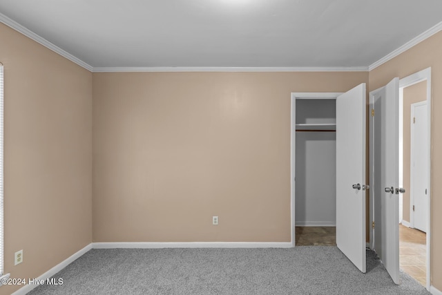 unfurnished bedroom with crown molding, a closet, and carpet