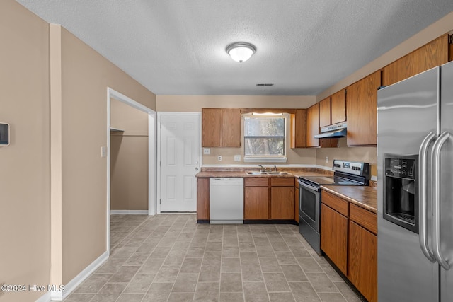 kitchen with sink, a textured ceiling, and appliances with stainless steel finishes