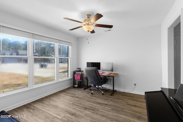 home office with hardwood / wood-style floors, ceiling fan, and a textured ceiling