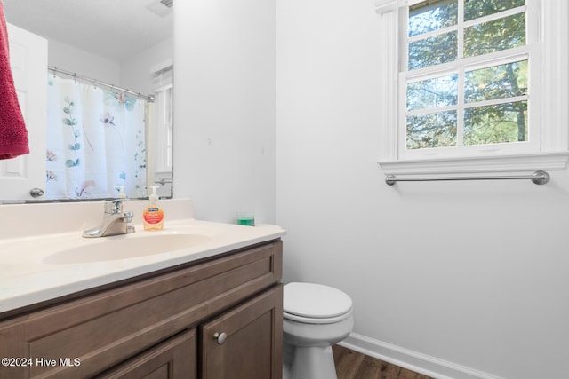 bathroom featuring a shower with curtain, hardwood / wood-style floors, vanity, and toilet