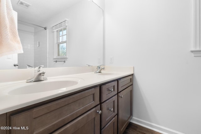 bathroom with a shower, vanity, and wood-type flooring