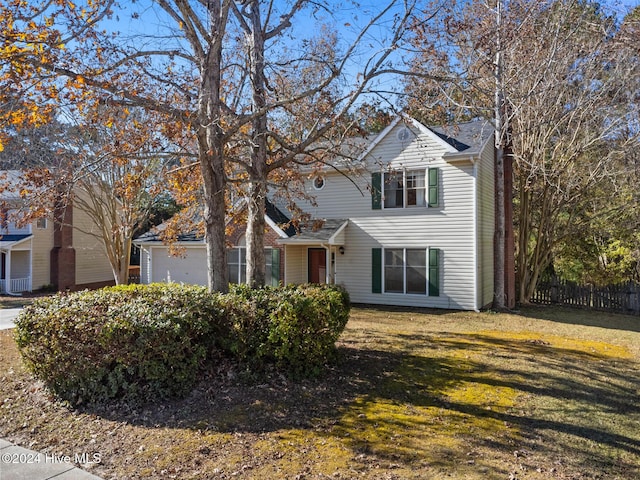 view of front property featuring a garage and a front lawn