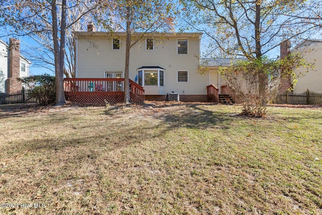 back of property featuring cooling unit, a wooden deck, and a lawn