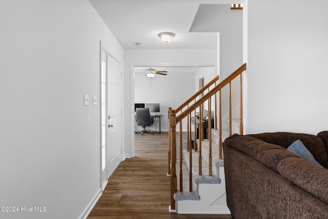 interior space with ceiling fan, wood-type flooring, and a textured ceiling