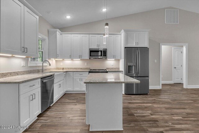 kitchen with a kitchen island, lofted ceiling, and appliances with stainless steel finishes