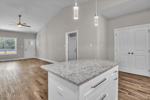 kitchen with white cabinetry, light hardwood / wood-style flooring, ceiling fan, and pendant lighting