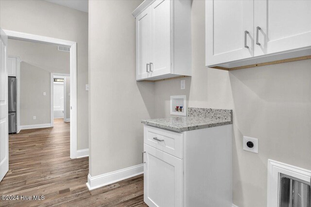 clothes washing area featuring washer hookup, hardwood / wood-style floors, cabinets, and hookup for an electric dryer