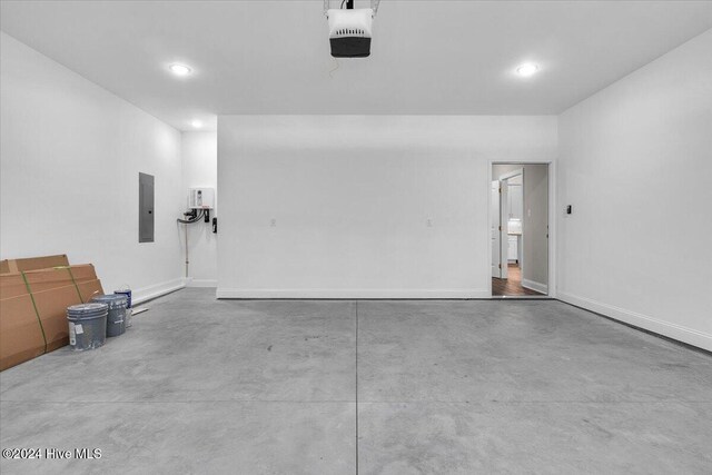 garage featuring electric panel and a garage door opener