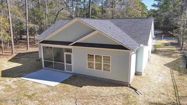 rear view of property with a sunroom and a patio area