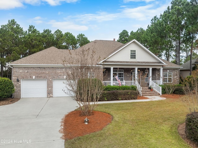 view of front of property featuring a front yard, a porch, and a garage