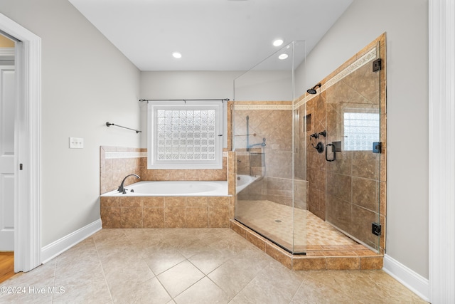 bathroom featuring plus walk in shower, tile patterned flooring, and a wealth of natural light