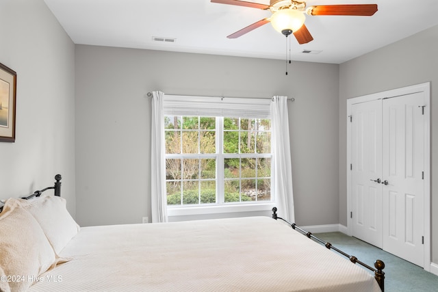 carpeted bedroom with ceiling fan and a closet