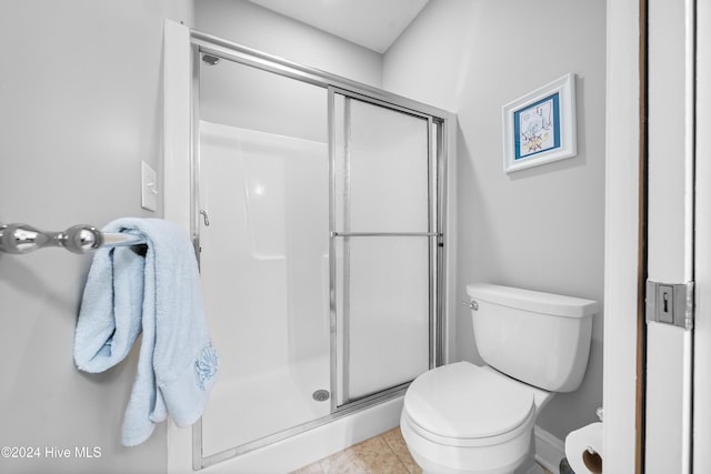 bathroom featuring tile patterned floors, an enclosed shower, and toilet