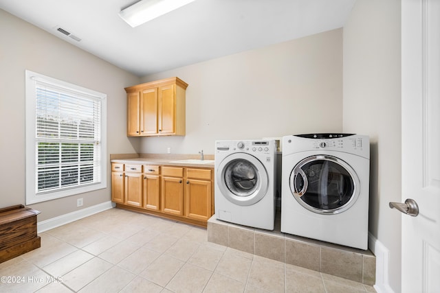 laundry room featuring light tile patterned flooring, cabinets, separate washer and dryer, and sink