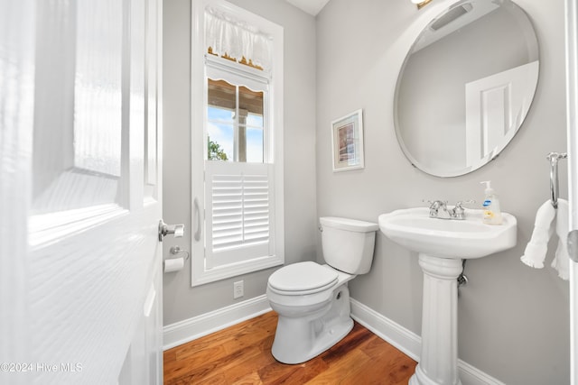 bathroom with hardwood / wood-style flooring and toilet