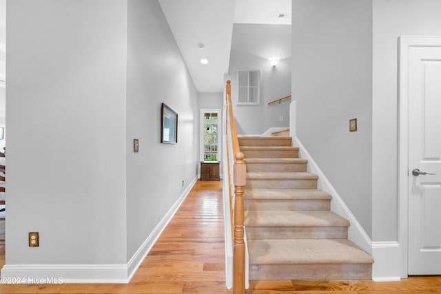 staircase with hardwood / wood-style floors