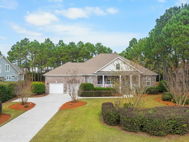 view of front of home featuring covered porch, a garage, and a front yard