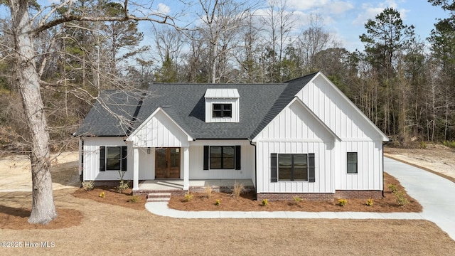 modern farmhouse featuring a shingled roof, board and batten siding, and a porch