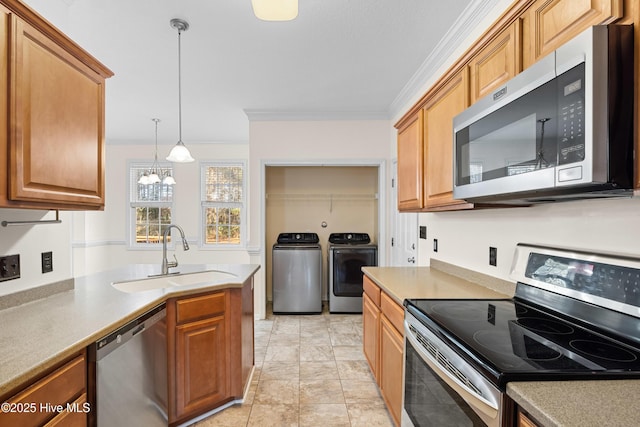 kitchen featuring sink, an inviting chandelier, independent washer and dryer, appliances with stainless steel finishes, and ornamental molding