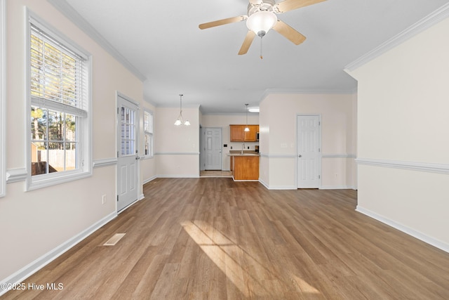 unfurnished living room featuring ceiling fan with notable chandelier, light hardwood / wood-style floors, ornamental molding, and sink