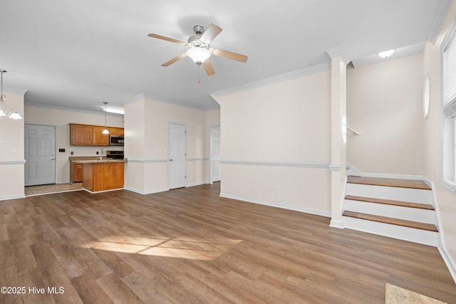 unfurnished living room featuring ceiling fan, hardwood / wood-style flooring, and ornamental molding