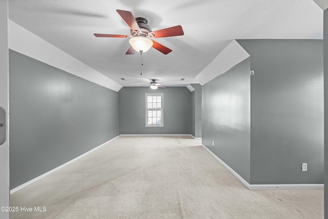 spare room featuring light carpet, ceiling fan, and lofted ceiling