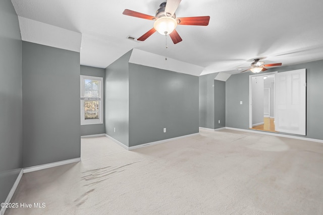 unfurnished room featuring light carpet, vaulted ceiling, and ceiling fan