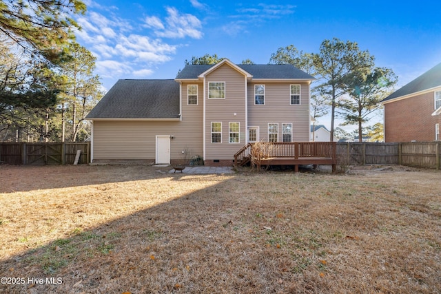 back of property featuring a lawn and a deck