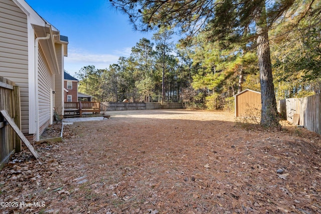 view of yard featuring a shed and a wooden deck