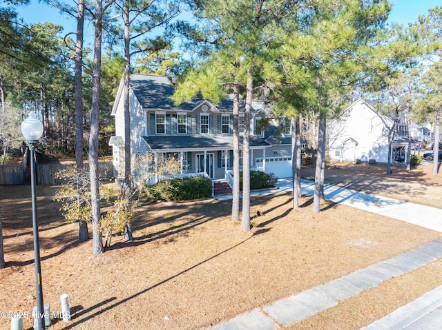 colonial home with covered porch and a garage