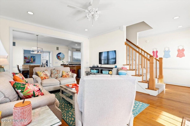 living room with wood-type flooring, ceiling fan, and ornamental molding