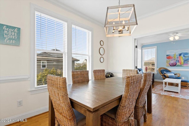 dining area featuring hardwood / wood-style floors, ceiling fan with notable chandelier, and ornamental molding