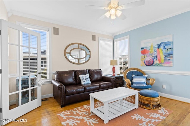 living room with light hardwood / wood-style floors, ceiling fan, and ornamental molding