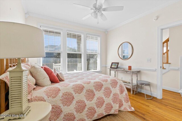 bedroom with hardwood / wood-style floors, ceiling fan, and crown molding