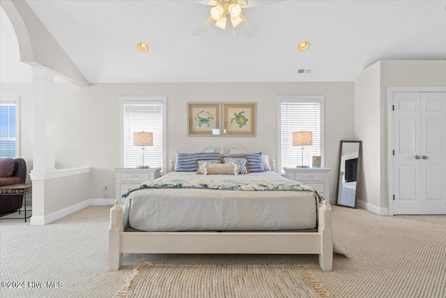 bedroom with multiple windows, ceiling fan, light colored carpet, and lofted ceiling