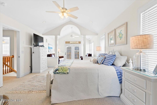 carpeted bedroom with french doors, decorative columns, vaulted ceiling, and ceiling fan