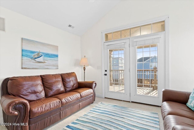 living room featuring light colored carpet and vaulted ceiling