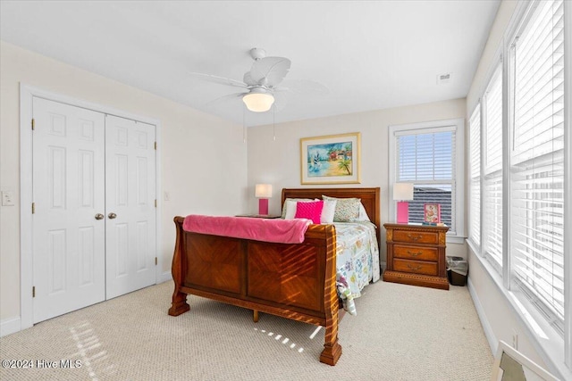 carpeted bedroom featuring ceiling fan and a closet