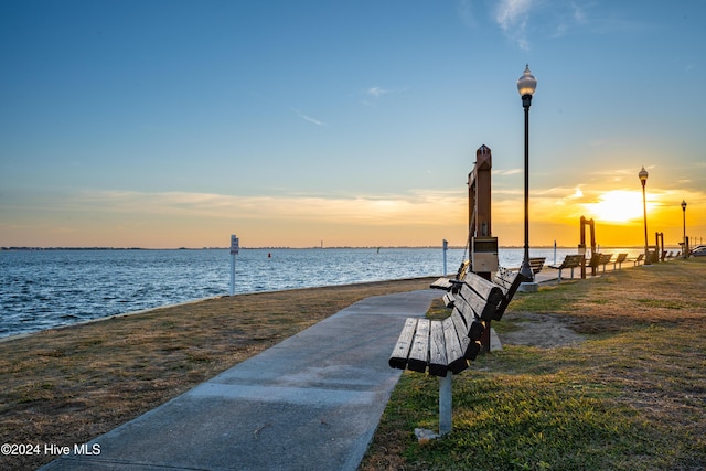 view of dock featuring a lawn and a water view