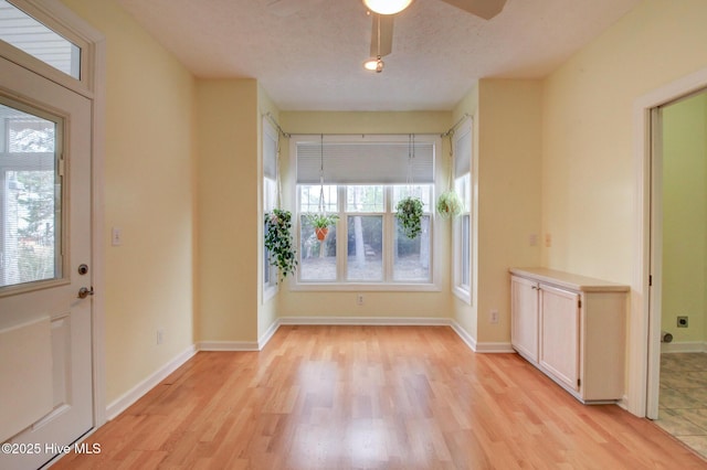 entryway with ceiling fan, light wood-type flooring, and a textured ceiling