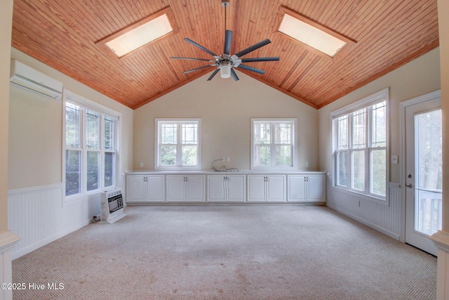 interior space with a wall mounted air conditioner, lofted ceiling with skylight, a healthy amount of sunlight, and wood ceiling