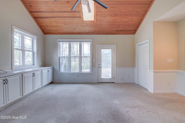 unfurnished room with light carpet, lofted ceiling with skylight, and wood ceiling