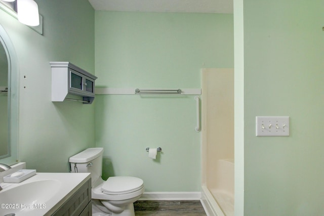 bathroom with wood-type flooring, vanity, toilet, and walk in shower