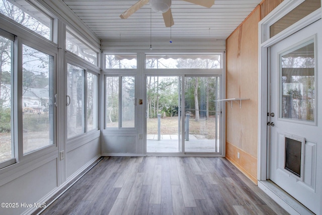 unfurnished sunroom featuring a wealth of natural light and ceiling fan