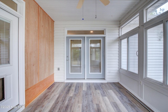 unfurnished sunroom with ceiling fan