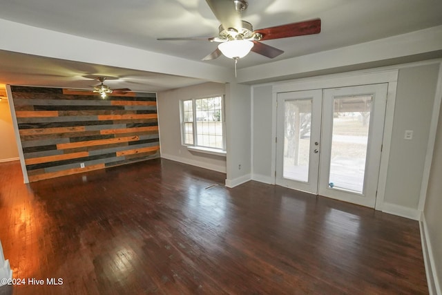 unfurnished living room with dark hardwood / wood-style flooring, ceiling fan, and french doors