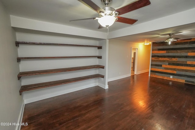 unfurnished living room with ceiling fan and dark wood-type flooring