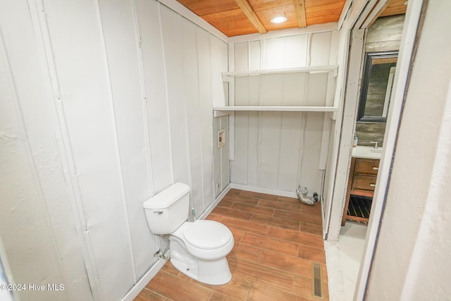 bathroom featuring hardwood / wood-style flooring, toilet, and wooden ceiling