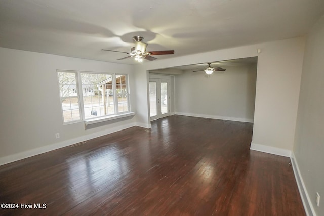 unfurnished room with ceiling fan, dark hardwood / wood-style flooring, and french doors