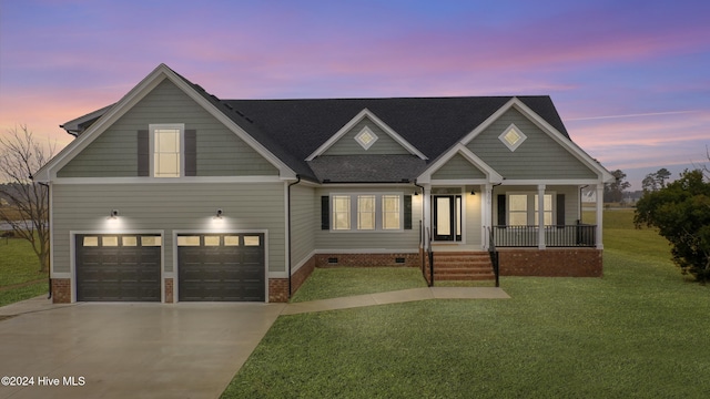 craftsman inspired home featuring a porch, a garage, and a yard